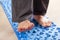 Man doing flatfoot correction gymnastic exercise walking on massage mat at home