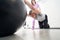 Man doing physical therapy exercise with gym ball in clinic