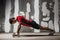 Man doing push ups on dumbbells the wall backdrop