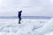 A man doing solo outdoor activity, enjoying time alone in nature, walking on frozen lake in winter