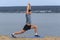 Man doing yoga outdoor. Young man practicing yoga fitness exercise outdoor at beautiful sea.
