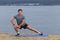 Man doing yoga outdoor. Young man practicing yoga fitness exercise outdoor at beautiful sea. Meditation and relaxation.