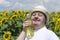 Man with down syndrome holding bottle of fresh sunflower oil. Happy farmer with fresh harvest