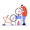 Man drawn in a flat vector style repairs a bicycle wheel on a table in a workshop