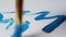 A man draws a blue paint on a white sheet of a Christmas tree, close-up, the new year 2109, Xmas