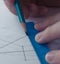 A man draws a scheme on white paper with a pencil using a ruler.