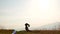 A man with dreadlocks is doing yoga at dawn. Mountains of Carpathians, Ukraine