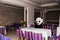 Man dressed in panda costume sitting in empty restaurant