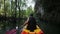 man drifts kayak past cliff and mangrove trees