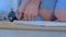 Man drilling round hole in chipboard wardrobe door for hinges making furniture.