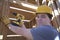 Man Drilling On A Wooden Beam At Site