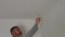 A man drills white wall, drill, concrete, electric drill, Close up hands hold electric drill in white room.