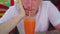 Man drinking cocktail in cafe. Adult guy sipping fresh fruit beverage through straw while sitting at table in street