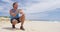 Man drinking cold pressed carrot juice on beach after run