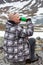 Man drinking energy drink on the mountain peak, one climber or mountaineer sitting on rock