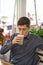 Man drinking large latte at a cafe table