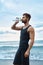 Man Drinking Refreshing Water After Workout At Beach. Drink