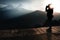 A man drinking a tea during sunrise and surrounded by mountains