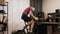Man is drinking water while training on stationary bicycle at home. Male cyclist is doing fitness cardio exercises and watching on