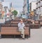 A man drinks coffee alone on a bench