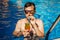 Man drinks tropical cocktail in swimming pool. All inclusive concept