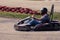 Man drive go kart on track back view