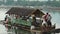 Man driven passenger bamboo raft or barge bringing passengers to lake shore