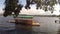 Man driven passenger bamboo raft or barge floats on lake