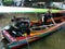 A man drives a boat with a powerful motor at the Taling Chan Floating Market in Bangkok