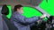 Man drives a car against a green background