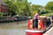 Man driving a barge or narrow boat.