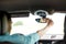 Man driving car adjusting rearview mirror