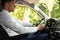 Man driving car feeling tea leaves scent from ventilation, closeup. Air freshener