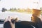 Man driving car while holding a cup of cold coffee and eating hamburger