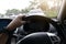 Man driving car single hand on steering wheel.