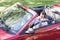 Man driving convertible car using cellular phone