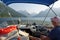 A man driving his boat on a beautiful sunny summer day with view of the calm water of jervis inlet, Sunshine Coast, BC, Canada