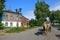 A man driving a horse drawn carriage in front of the old wooden house. Suzdal, Russia