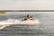 A man driving a jet ski , stunting and making spray of water drops