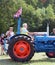 A man driving an old british tractor with union jacks at hebden bridge vintage weekend public vehicle show