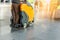 Man driving professional floor cleaning machine at airport or railway station. Floor care and cleaning service agency