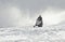 A man driving sports snowmobile in mountains.