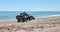 Man driving a tractor while collecting garbage on a seashore