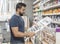 Man in drugstore selecting paint color for his work