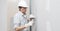 Man drywall worker or plasterer putting plaster on plasterboard wall using a trowel and a spatula, fill the screw holes, wearing