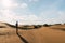 Man in the dunes desert in a sunny day