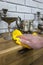 Man dusting wooden cabinet and pewter ornaments with a duster cloth