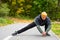 Man with dyed hair in blonde doing stretching at the city park.