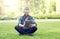 Man with earphones and tablet pc sitting on grass