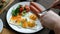 Man eating breakfast. Knife and fork in hand. American style breakfast with fried eggs, sausage, salad and toast.